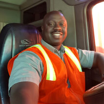 A man sitting in the driver 's seat of a bus.